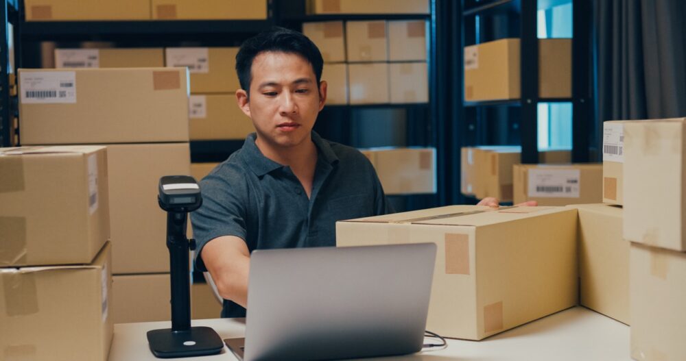 Bad Returns Cost Retailers Customers as Nine in Ten Shoppers Say They Won’t Buy Again 2 Asian businessman use barcode machine scan customer data in paper box and type register online information order detail in laptop for send express delivery at warehouse. Startup business concept.