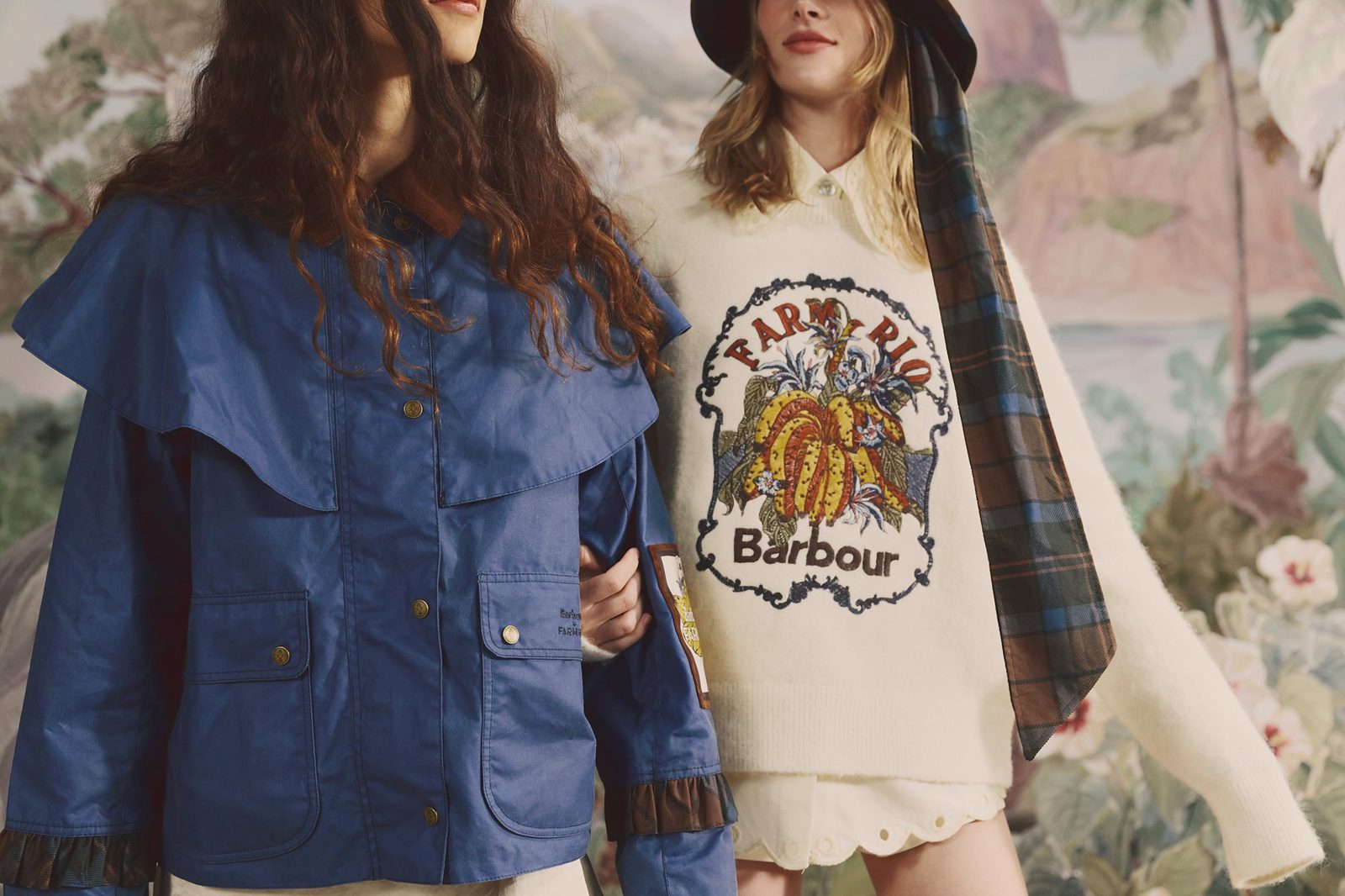 Two models in a blue Barbour FARM Rio jacket with a caped collar and a cream knit with an embroidered FARM Rio and Barbour banana motif